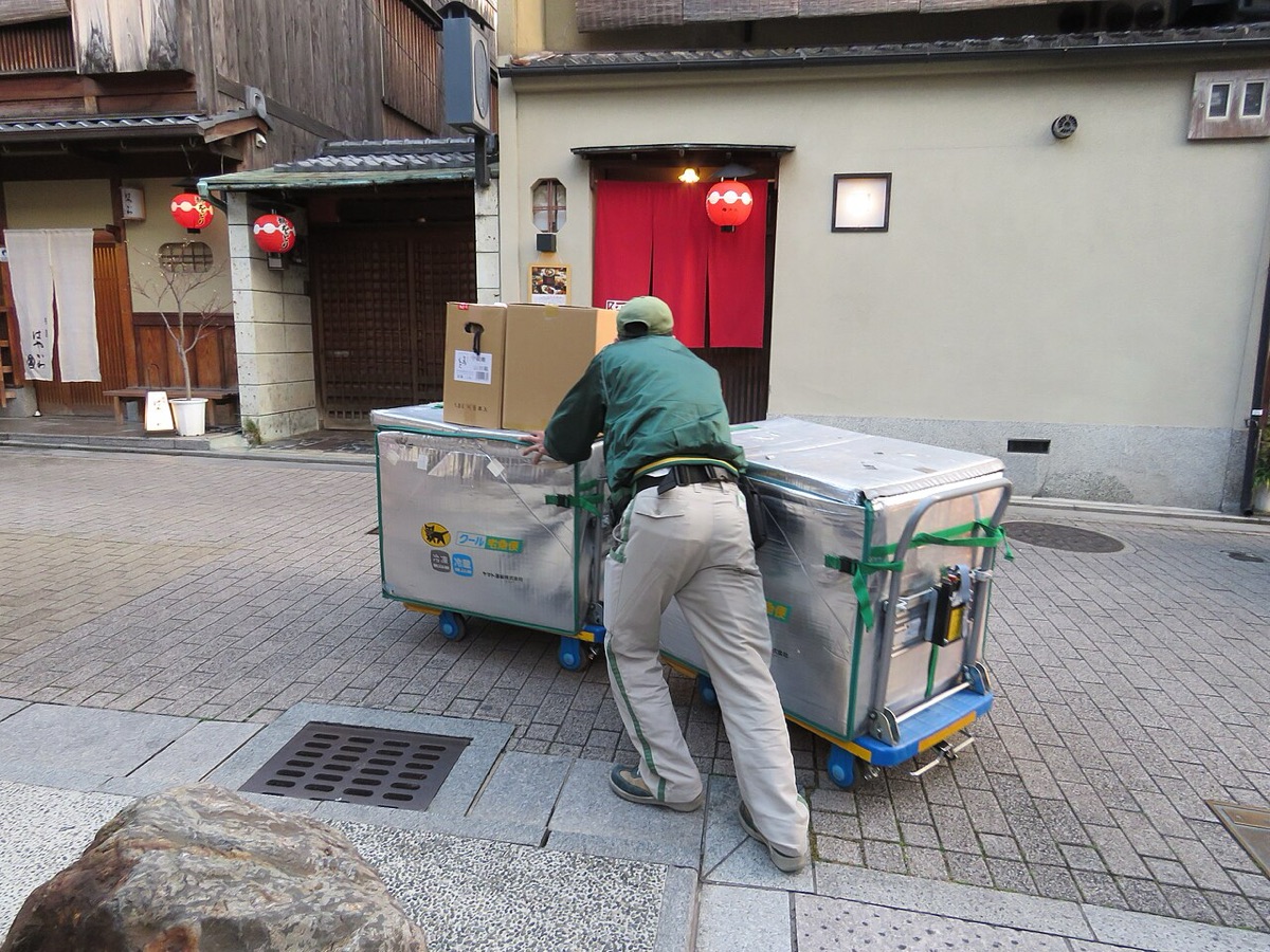京都祇園石板路上推著宅急便推車配送包裹的大和運輸人員，日本行李寄送服務