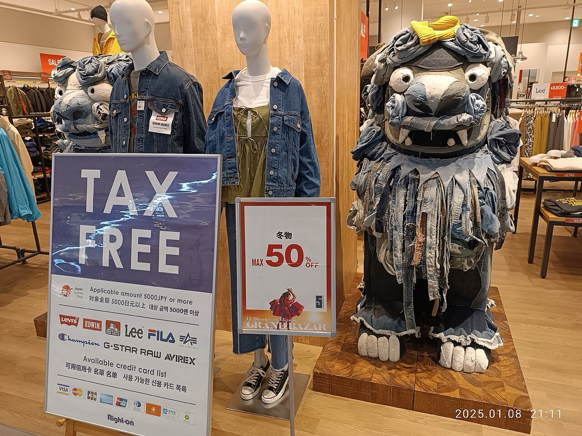 日本退稅新制上路前,沖繩商場服飾店門口標示 Tax Free 與 5000 日圓免稅門檻的告示牌