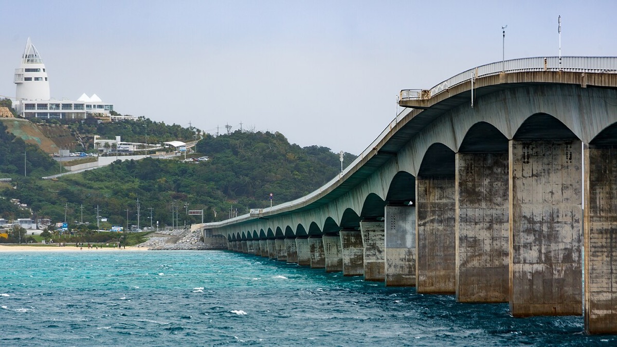 沖繩自駕必經的古宇利大橋橫跨翡翠色海面,遠方是古宇利島與海洋塔