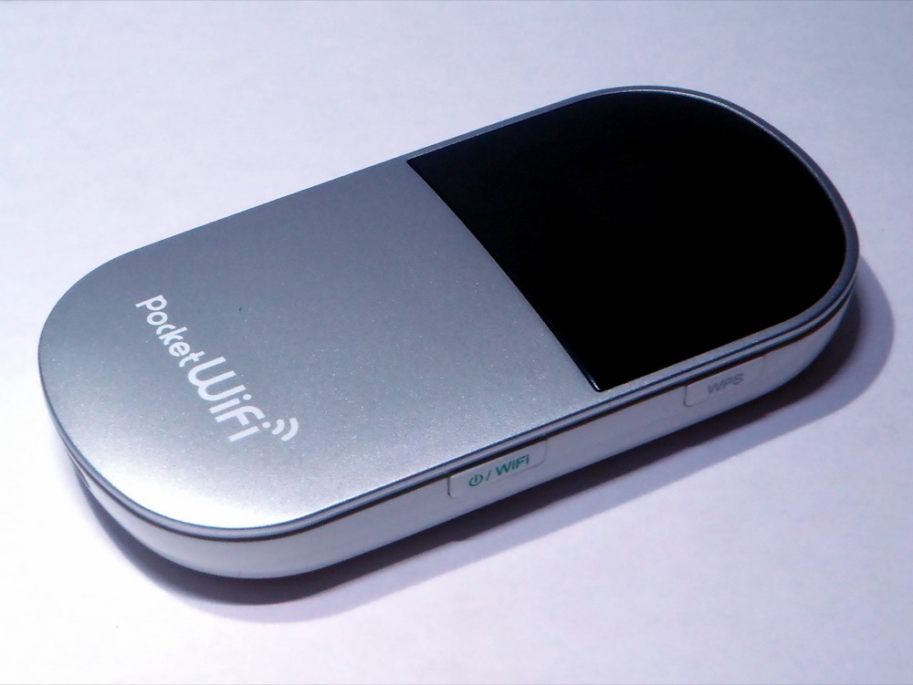 A silver Pocket WiFi mobile router on a desk