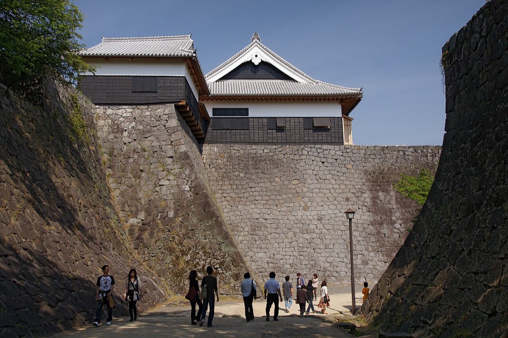Kumamoto Castle's main keep rising above its stone walls on a clear day