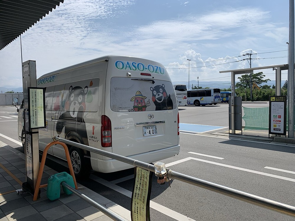 A shuttle minibus painted with Kumamon outside Aso Kumamoto Airport