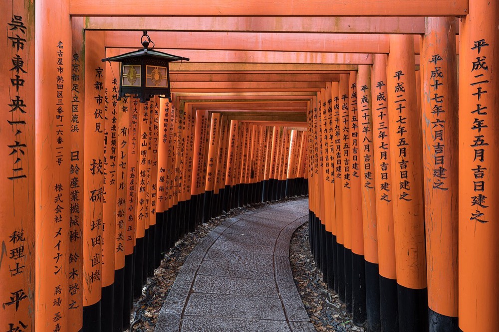 The torii path with hanging lanterns at the Senbon Torii of Fushimi Inari Taisha