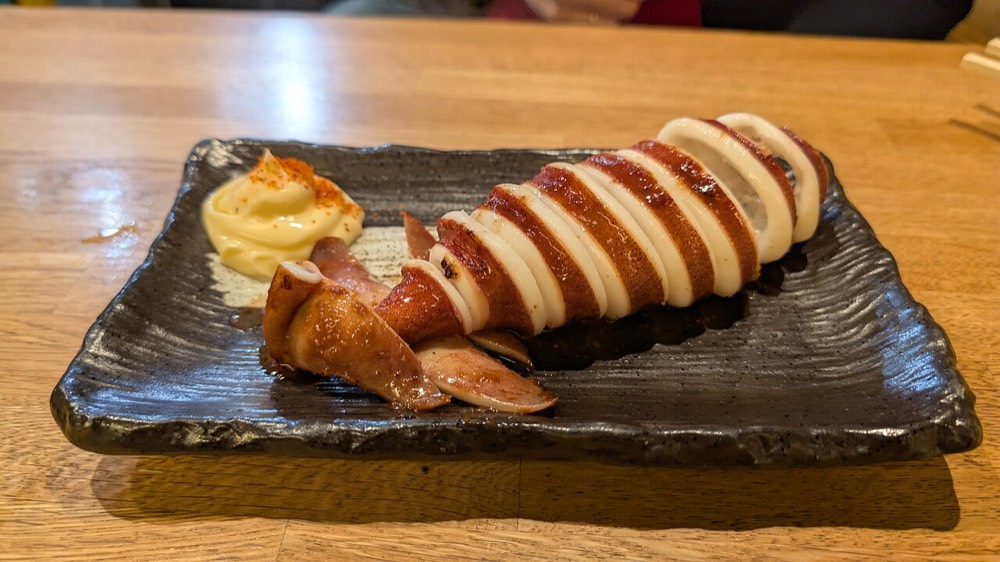 Squid freshly grilled in front of a shop at Nishiki Market, served on a plate
