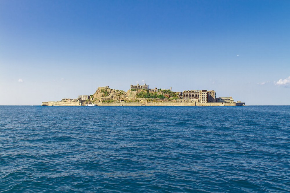 Gunkanjima seen from the sea, covered with abandoned buildings