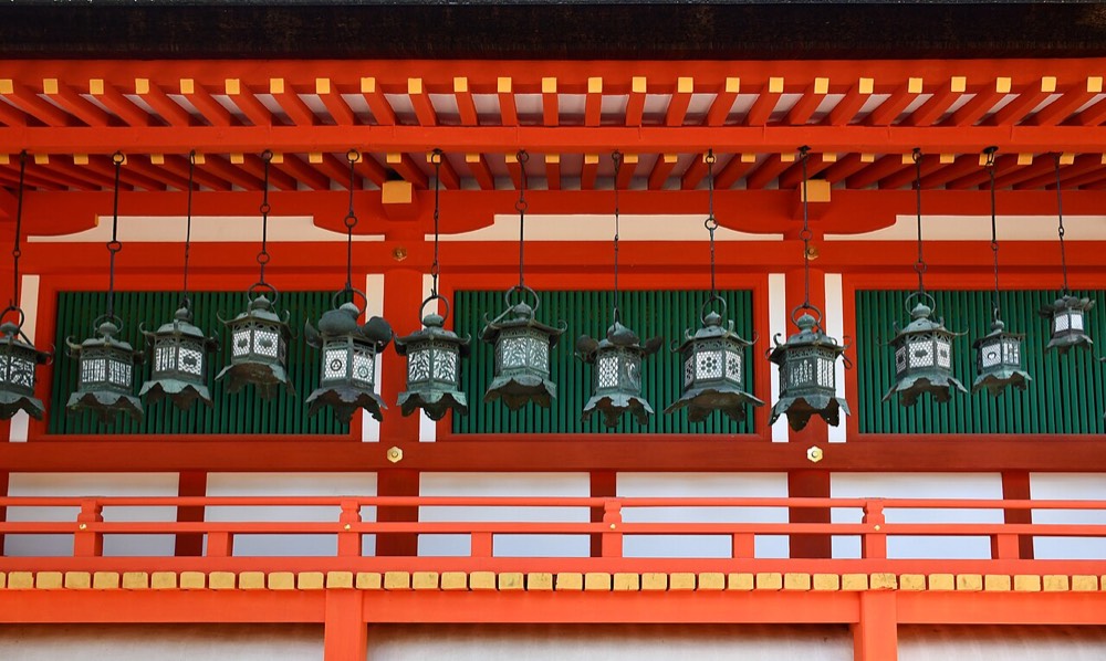 Bronze lanterns hanging from the vermilion corridor at Kasuga Taisha