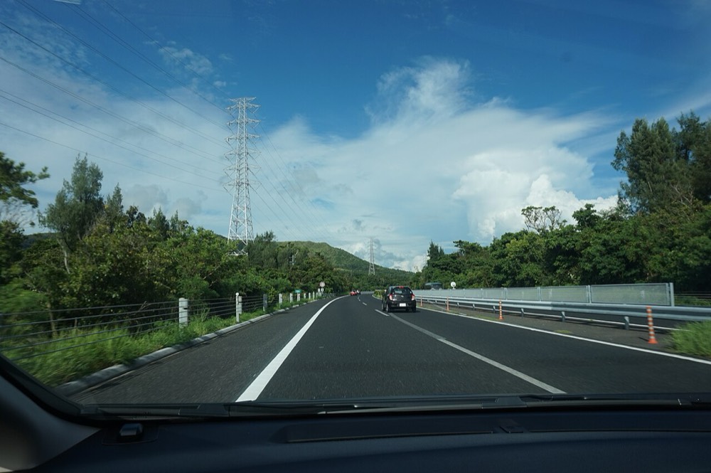 Traffic on the Okinawa Expressway with greenery on both sides