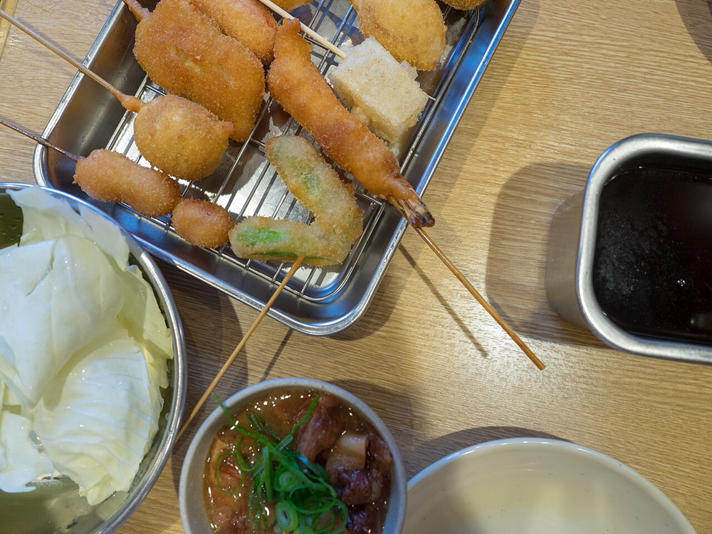 Fried skewers and two dipping sauces on a table