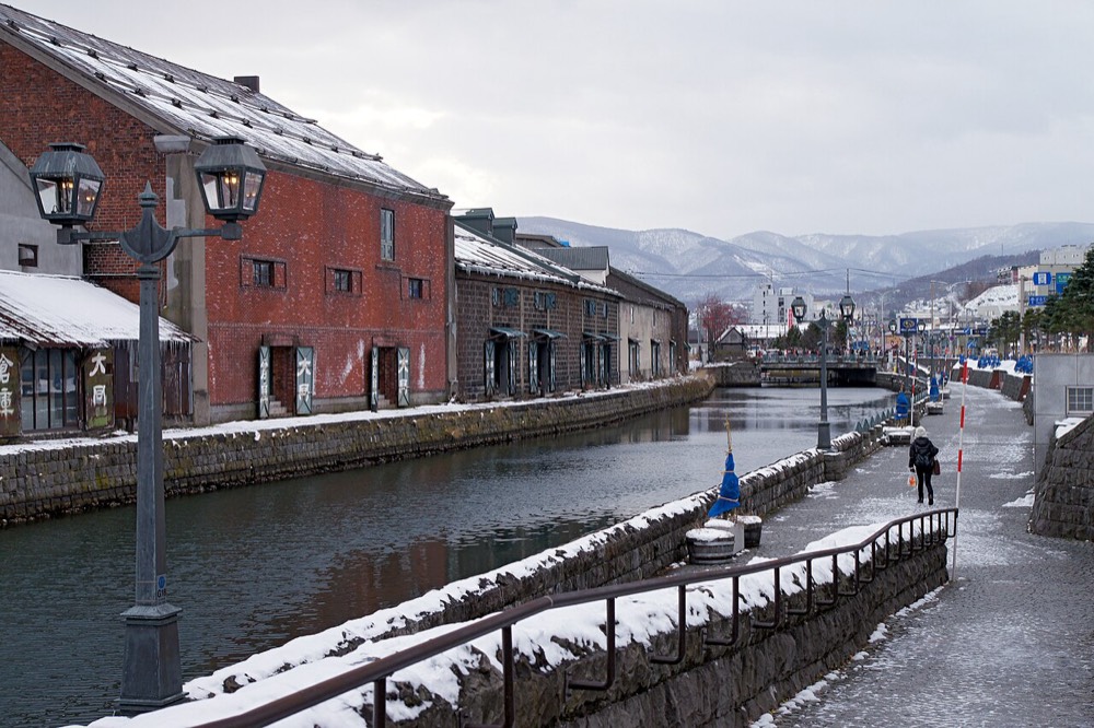 Otaru Canal under a light dusting of snow, lined with red-brick and stone warehouses