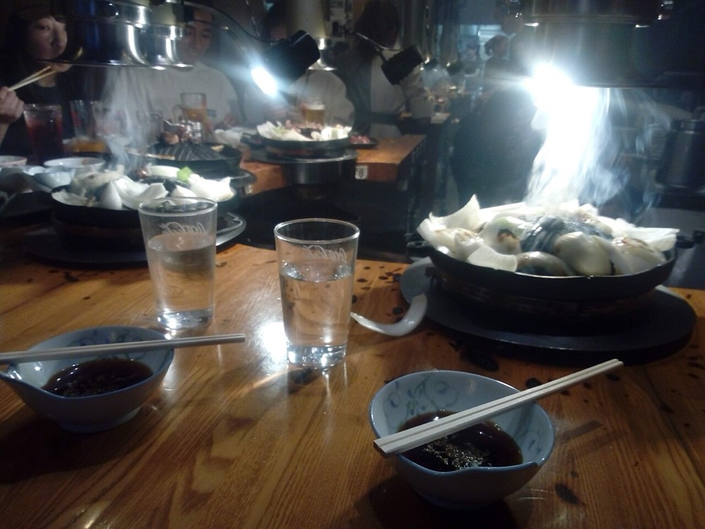 Seats at a Genghis Khan restaurant with lamb grilling over charcoal braziers
