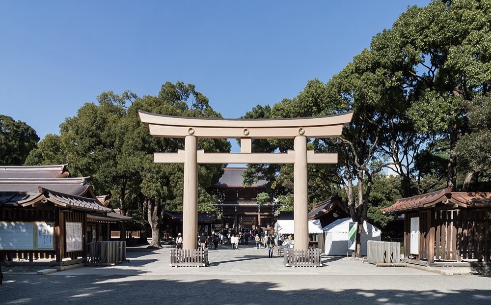 A tall wooden torii gate on the approach to Meiji Jingu