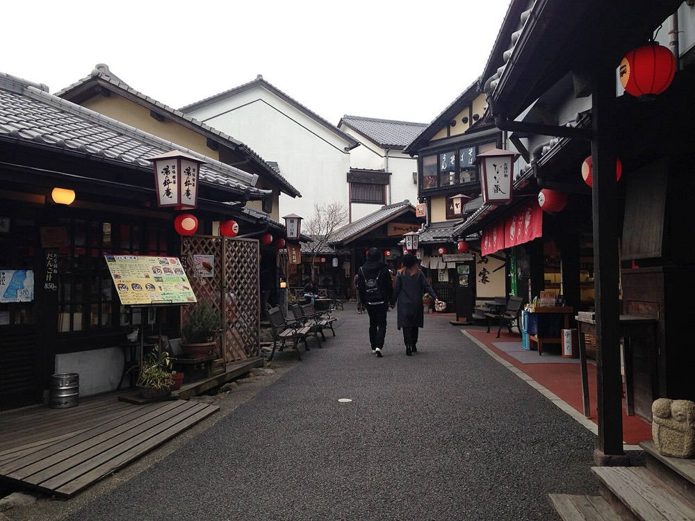Yunotsubo Yokocho in Yufuin Onsen, with small shops and pedestrians on both sides