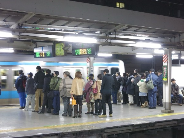 清晨在JR車站月台依地上標示排隊候車的乘客，日本自由行注意事項中的排隊禮儀